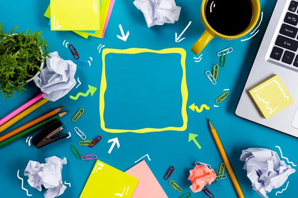 Schreibtisch mit Zubehör, weißer Notizblock, Tasse, Stift, PC, zerknülltes Papier, Blume auf blauem Hintergrund. Ansicht von oben — Stockfoto