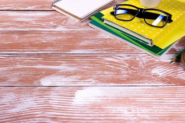 Schreibtisch mit Zubehör, weißer Notizblock, Tasse, Stift, PC, zerknülltes Papier, Blume auf Holzgrund. Ansicht von oben — Stockfoto