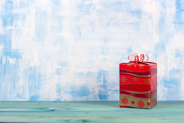 Christmas present box over blue wooden background, above view.