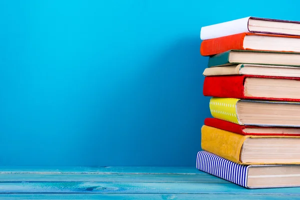 Pila de libros coloridos, fondo azul grueso, espacio de copia gratis —  Fotos de Stock