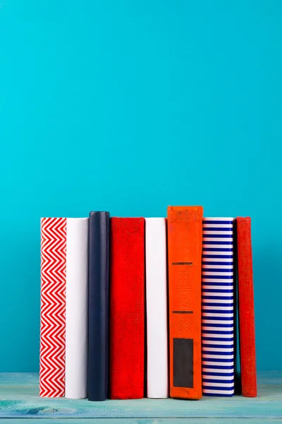 Stapel kleurrijke boeken, grungy blauwe achtergrond, presentexemplaar ruimte — Stockfoto