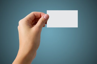 Mavi zemin üzerine beyaz kartvizit tutan el