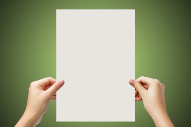 Hands holding a white paper blank isolated on green background