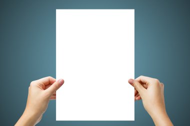 Hands holding a white paper blank isolated on blue background