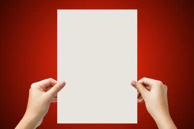 Hands holding a white paper blank isolated on red background