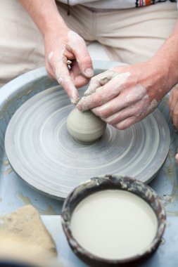 Çanak çömlek. El eşya yaptı. Eller seramik tekerlek üzerinde çalışıyor. Potter 