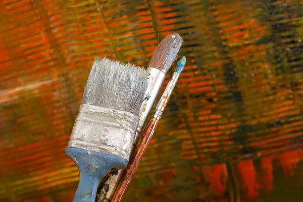 苦しそうなキャンバスを抽象化します。ブラシやパレットのオイル塗料. — ストック写真