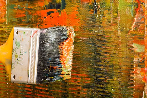 Lienzo dolorido abstracto. Pinceles y pinturas al óleo en una paleta . — Foto de Stock
