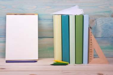 Okula dönüş. Ahşap masa üzerinde renkli kitap yığını.