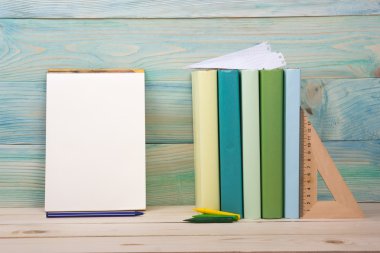 Okula dönüş. Ahşap masa üzerinde renkli kitap yığını