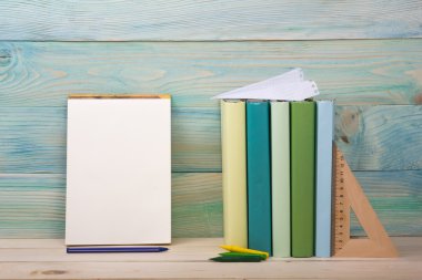 Okula dönüş. Ahşap masa üzerinde renkli kitap yığını