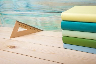 Okula dönüş. Ahşap masa üzerinde renkli kitap yığını