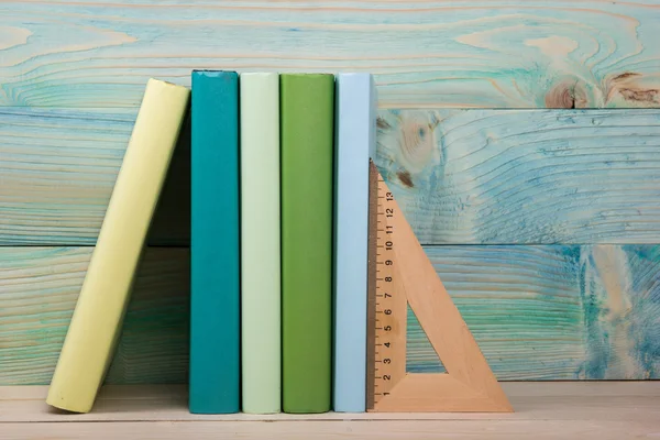 Okula dönüş. Ahşap masa üzerinde renkli kitap yığını.