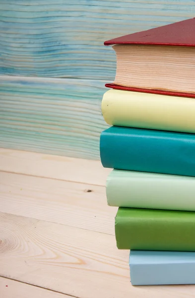Возвращайся в школу. Стопка разноцветных книг на деревянном столе . — стоковое фото