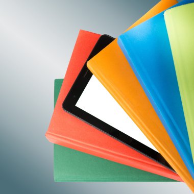 Stack of colorful books and electronic book reader. Electronic library concept. Back to school. Copy space