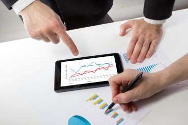 Business people on a meeting analyzing financial reports discuss