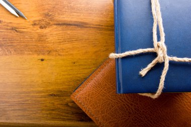Top view of colorful hardback books on yellow background. Composition with vintage old hardback books, diary, fanned pages on wooden deck table. Books stacking. Back to school. Education background.