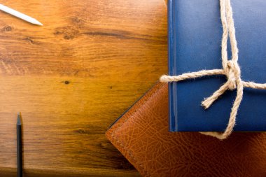 Top view of colorful hardback books on yellow background. Composition with vintage old hardback books, diary, fanned pages on wooden deck table. Books stacking. Back to school. Education background.