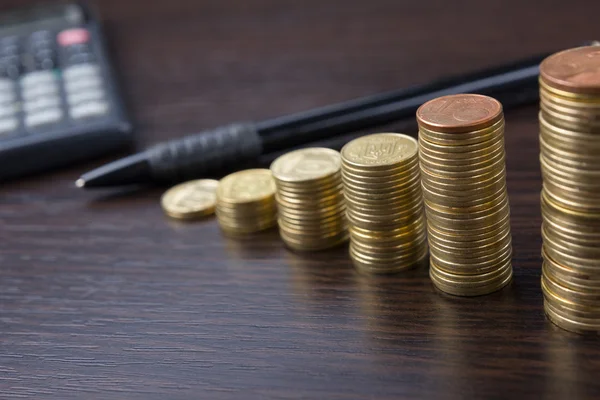 Geschäftskonzept des Zählens von Geld, Taschenrechner, Stift am Büroarbeitsplatz, Büro. Stapel von Münzen auf einem hölzernen Hintergrund. Hintergrund der finanziellen Nahaufnahme. — Stockfoto