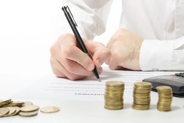 Business concept. Businessman's hand counting losses and profit working with statistics, analyzing financial results on calculator and signing documents at office workplace, office work. Stack of coins. Financial Accounting - money and calculator. — Stock Photo, Image