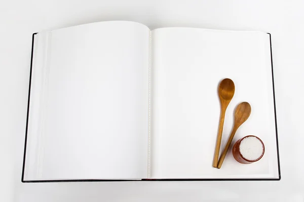 Open cookbook and spoon on white background — Stok fotoğraf