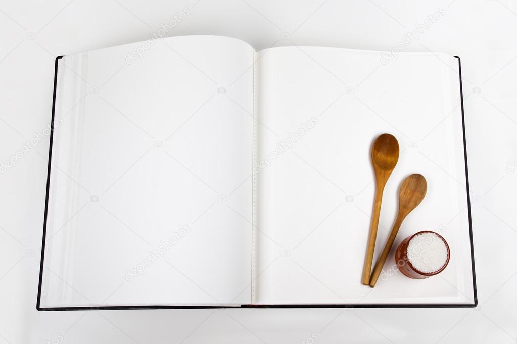 Open cookbook and spoon on white background