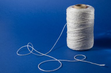 Mavi zemin üzerine beyaz iplik. Renkli biriktiricileri iplik. Dikiş arka plan