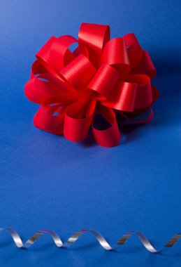 Big red bow on blue background. Christmas, party decoration.