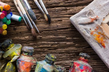 Row of artist paintbrushes on old natural grunge wooden background