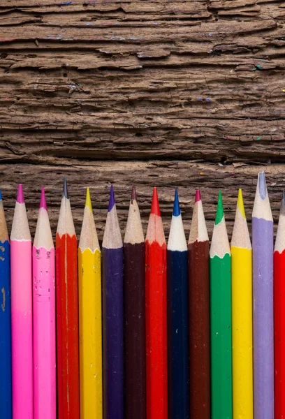 Fila de lápices de dibujo de colores sobre fondo de madera natural grunge — Foto de Stock