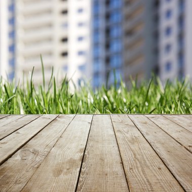 Wooden perspective floor with planks on blurred grass real estate