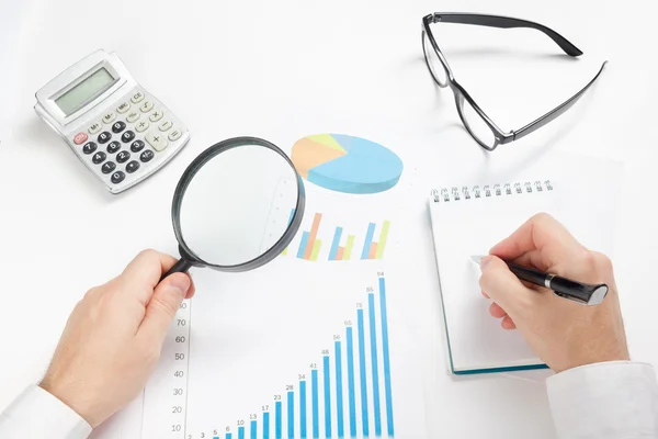 Geschäftsmann, der Verluste und Gewinne zählt, mit Statistiken arbeitet und die finanziellen Ergebnisse analysiert — Stockfoto