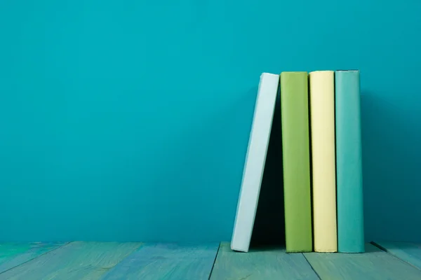 Fila de livros coloridos, fundo azul grungy, espaço livre da cópia — Fotografia de Stock