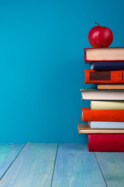Row of colorful books, grungy blue background, free copy space