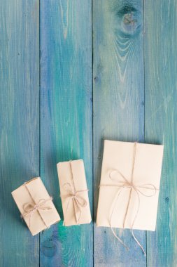 Festive present boxes with ribbon on turquoise painted wooden background. Place for text. Selective focus.
