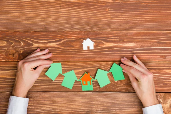 Conceito imobiliário. Mãos segurando figuras de casa de papel . — Fotografia de Stock