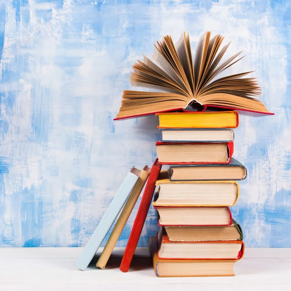 오래 된 빈티지 다채로운 hardback 책, 나무로 되는 갑판 테이블에 예술적 파란색 배경 일기 구성. 책 스태킹입니다. 학교 돌아가기. 공간에 복사 합니다. 교육 배경 — 스톡 사진