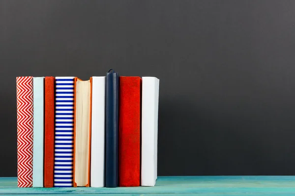 Composition with old vintage colorful hardback books, diary on black board background — Stock Photo, Image