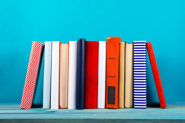 Rij van kleurrijke boeken, grungy blauwe achtergrond, presentexemplaar ruimte — Stockfoto