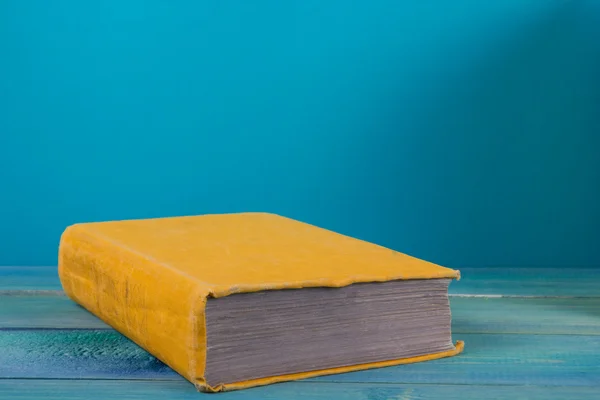 Yellow book on grungy blue background, free copy space — Zdjęcie stockowe