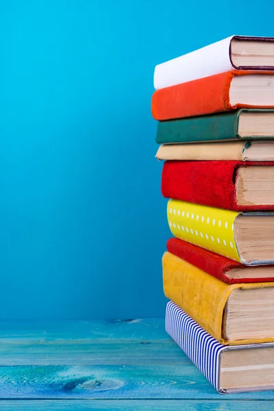 Stack of colorful books, grungy blue background, free copy space — Stock Photo, Image