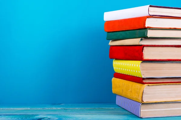 Stack of colorful books, grungy blue background, free copy space — Stock Photo, Image