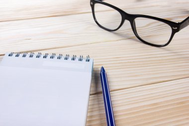 Okula dönüş. Boş not defteri, defter kalem ve ahşap zemin üzerine gözlük ile. Uzay kopyalayın. Eğitim arka plan