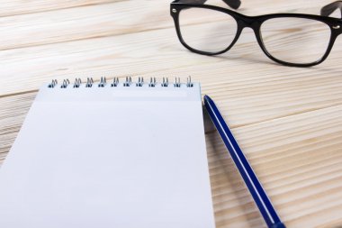 Okula dönüş. Boş not defteri, defter kalem ve ahşap zemin üzerine gözlük ile. Uzay kopyalayın. Eğitim arka plan