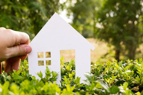 Real Estate Concept Paper model house against green grass background. Ecological building. Top view. — Stok fotoğraf