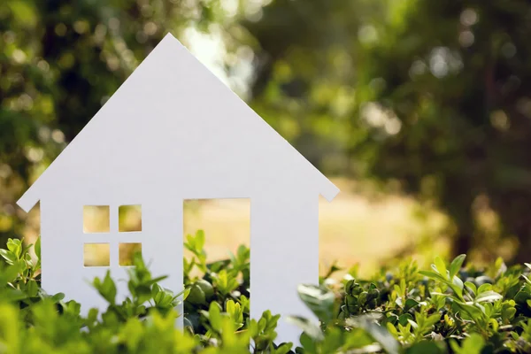 Real Estate Concept. Paper model house against green grass background. Ecological building. Top view. — ストック写真