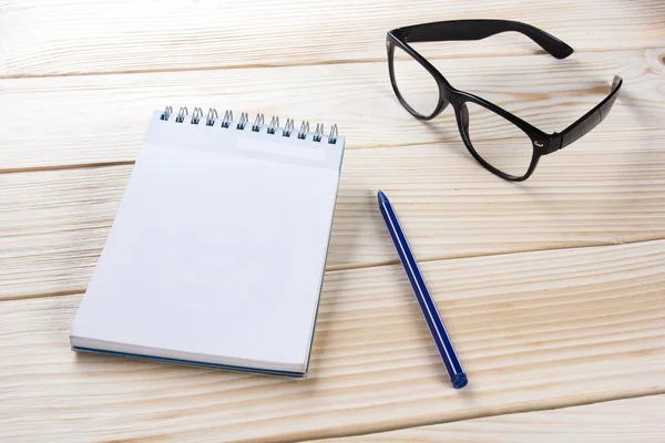 Zurück zur Schule. Notizblock, Notizbuch mit Stift und Brille auf Holzgrund. Kopierraum. Hintergrund der Ausbildung — Stockfoto