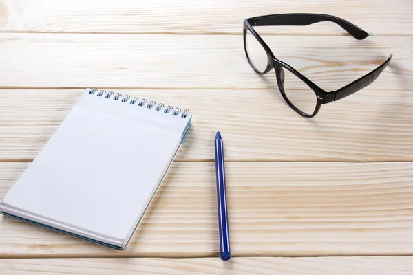 Zurück zur Schule. Notizblock, Notizbuch mit Stift und Brille auf Holzgrund. Kopierraum. Hintergrund der Ausbildung — Stockfoto