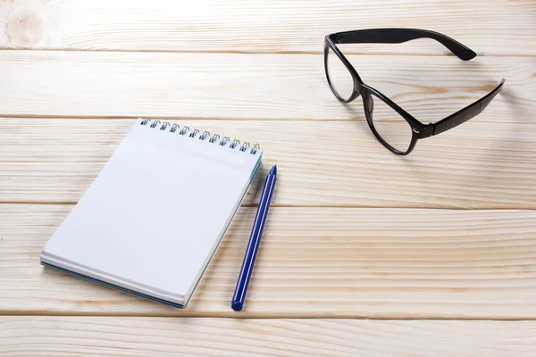 De vuelta a la escuela. Bloc de notas en blanco, cuaderno con bolígrafo y gafas sobre fondo de madera. Copiar espacio. Formación profesional —  Fotos de Stock