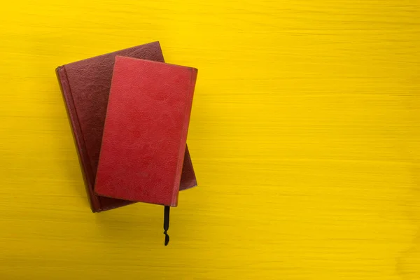 Red hardback books on yellow background. — Stock Photo, Image